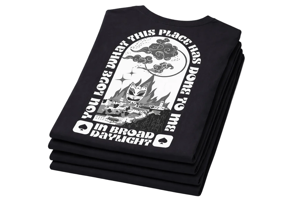 Stack of black t-shirts with white graphic design on a white background